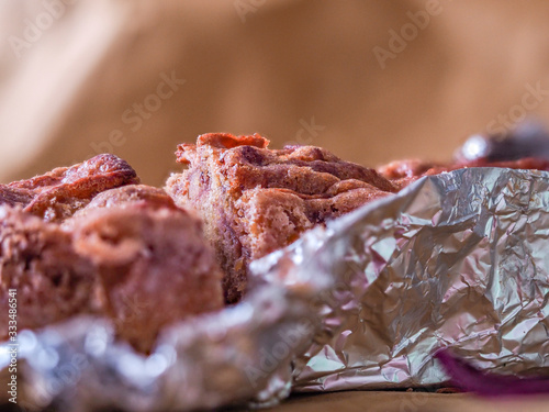 A photo of an whole flour apple pie in allu foil, on a dark rustic brown background with apples and  biologic eggs photo photo