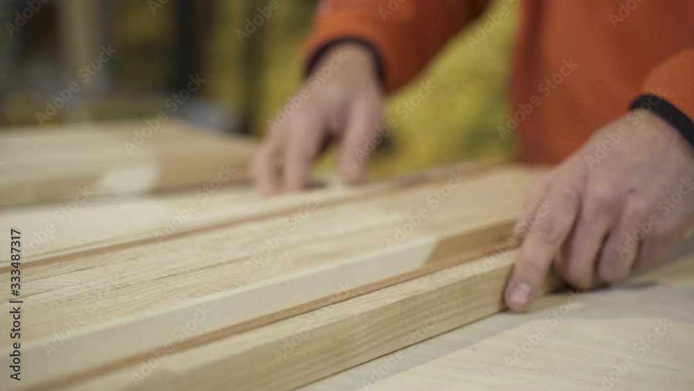Carpenter sorting wooden boards Carpenter sorting wooden boards