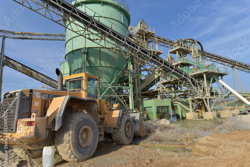 Gravel pit: building and wheel loader loading gravel onto a truck