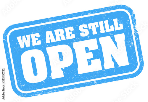 grungy blue WE ARE STILL OPEN stamp or sign vector illustration