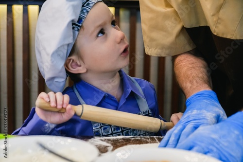 Kid in chef hat cooking piz...