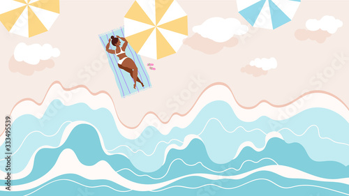 Woman sunbathing on the sea shore. Waves beating, white clouds in the air. Top dow view. summertime and travel concept.