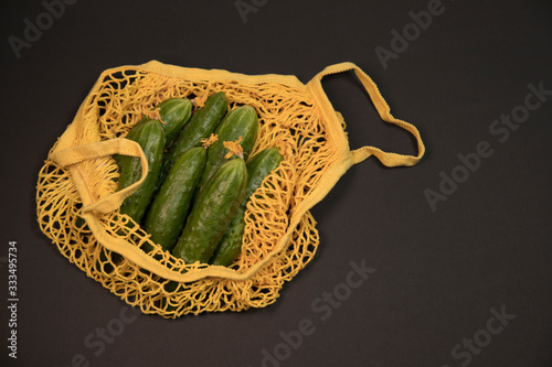 Fresh green cucumbers vegetables in reusable shopping eco-frendly mesh ba