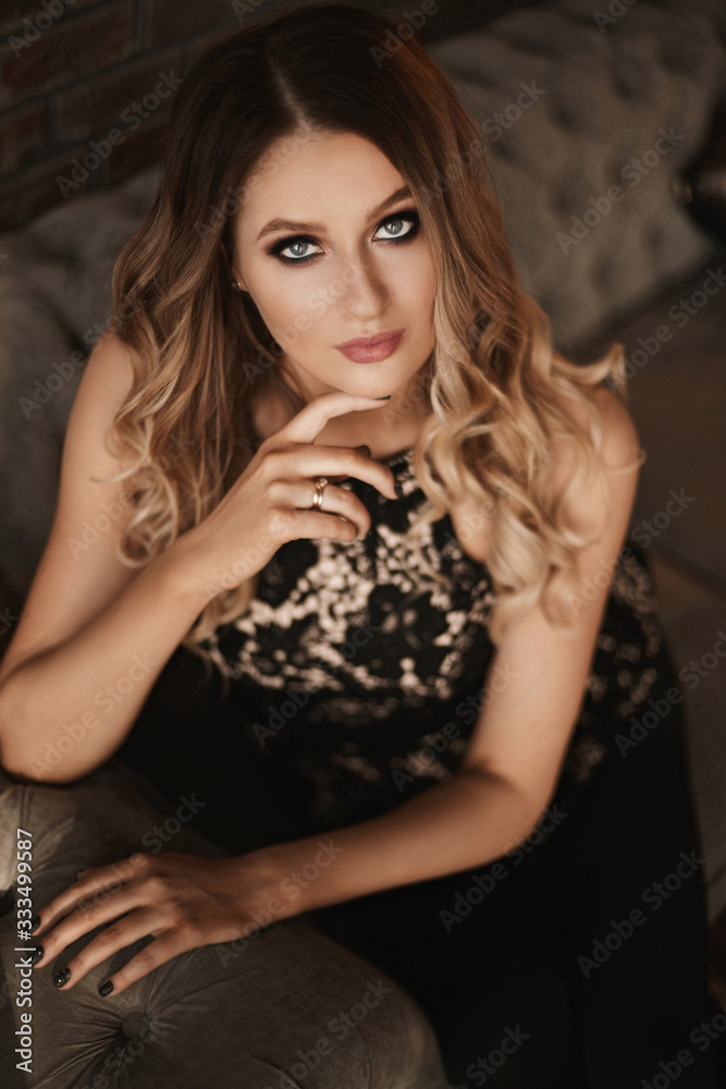 Young woman with blond hair and perfect trendy makeup. Beautiful blonde model girl with modish makeup, deep blue eyes and seductive look. Concept of modish official makeup and smooth skin Young woman with blond hair and perfect trendy makeup. Beautiful blonde model girl with modish makeup, deep blue eyes and seductive look. Concept of modish official makeup and smooth skin