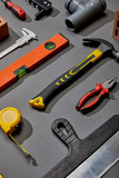 flat lay with measuring tape, calipers, hammer, screwdriver, brush, angle keys, putty knife and spirit levels on grey background