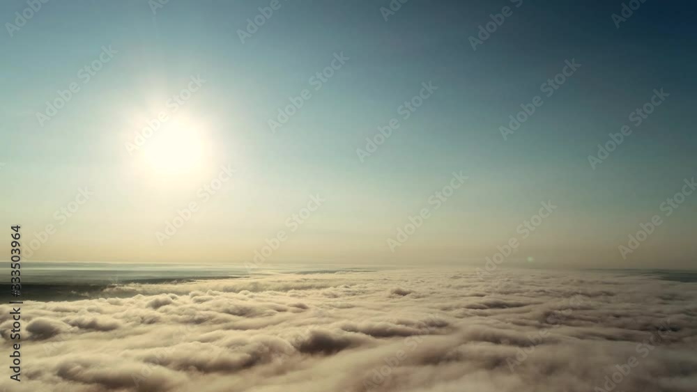 4k timelapse low angle view cloudscape with wind blowing white fluffy clouds passing the sun in clear sky with sunlight through the cloud.