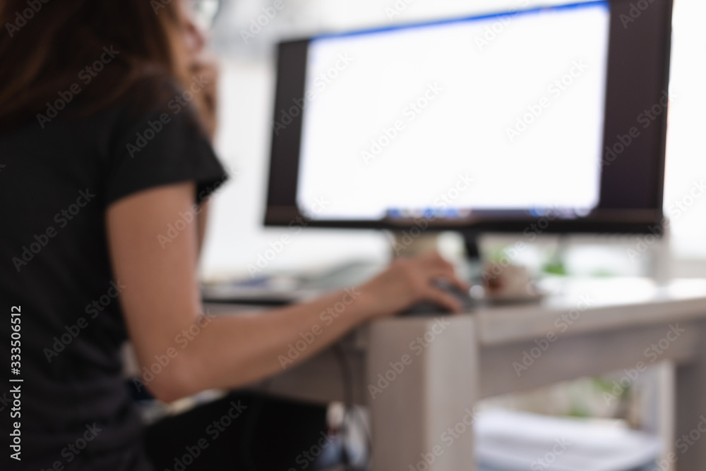 Blurred image of woman working on computer from home. Blurred image of woman working on computer from home.