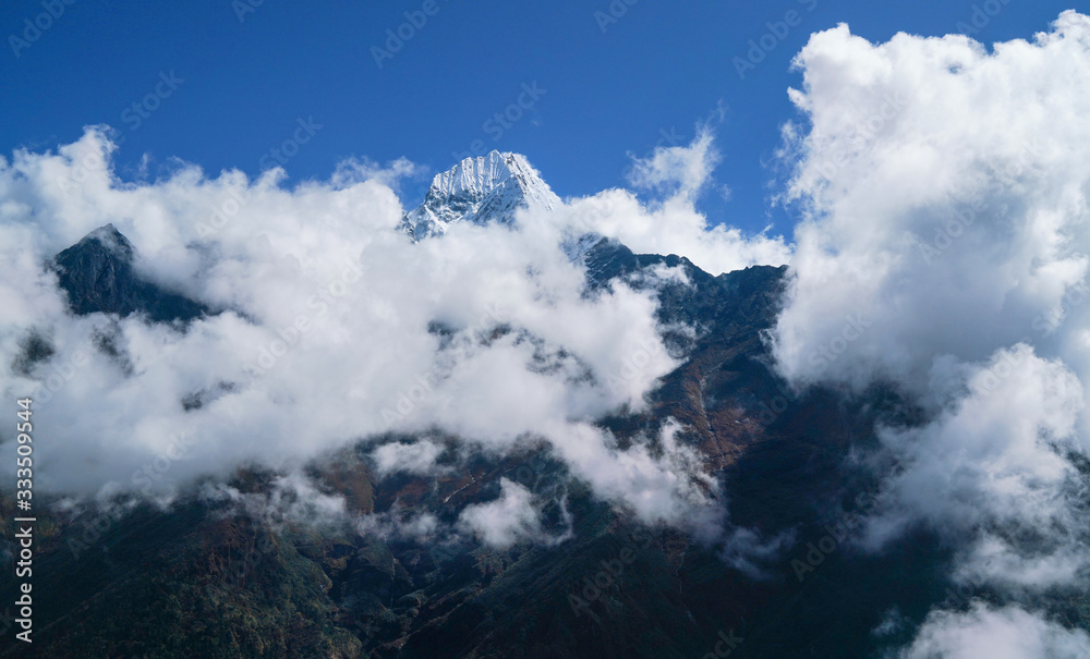  Thamserku 6608m mountain summit covered with clouds landscape photo in the eastern Nepal Himalayas.
