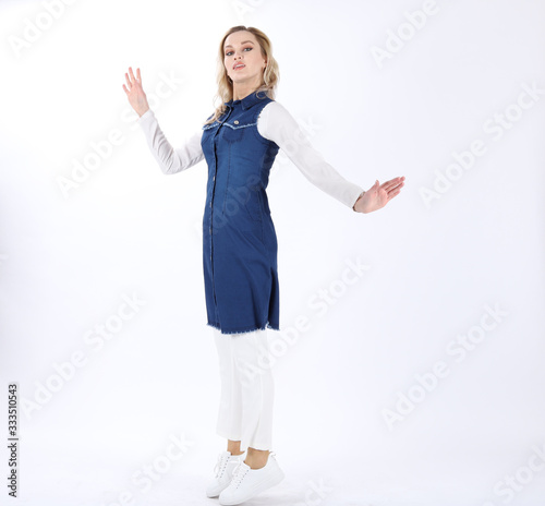 Fashion photo of a beautiful young woman in a pretty dress with flowers posing over white background. Fashion photo