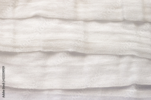white color woven cotton gauze fabric background texture. close up top view. Selective soft focus. Shallow depth of field. Text copy space.