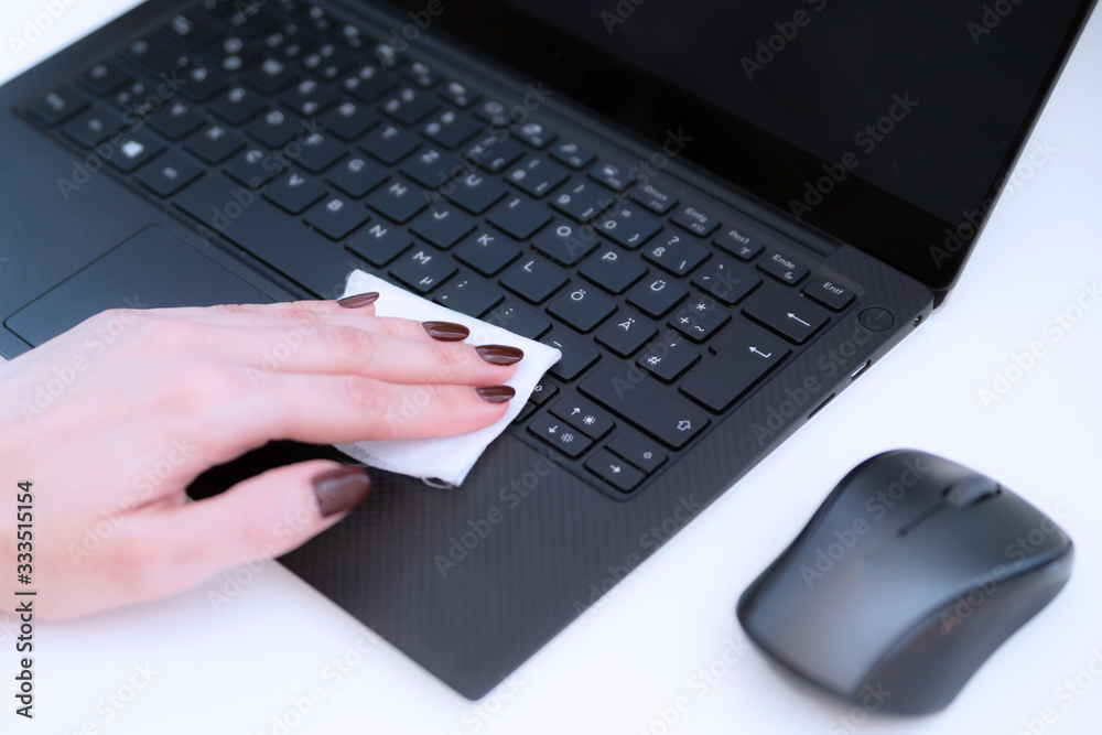 female hand disinfects the keyboard and mouse with a napkin with antibacterial gel female hand disinfects the keyboard and mouse with a napkin with antibacterial gel