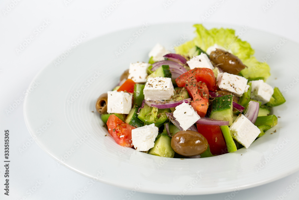 Greek salad on a plate on a white background