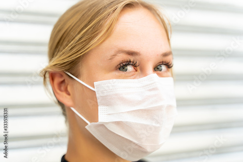 Profile of a woman with blue eyes with a mask on her face protecting against the coronavirus