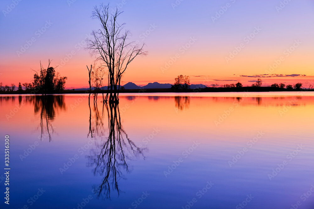 Amazing sunset over a relaxing tranquil lake with reflections.