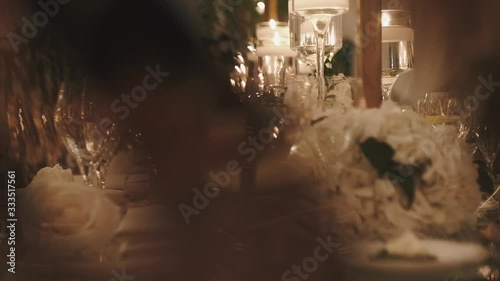Romantic serving of table, shiny glasses in the light rays, blind date, wedding table decoration in the evening