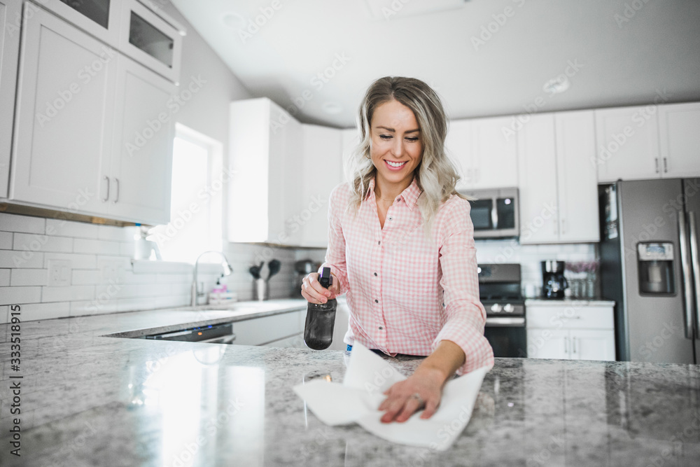Young woman cleaning her kitchen couters with disinfectant Young woman cleaning her kitchen couters with disinfectant