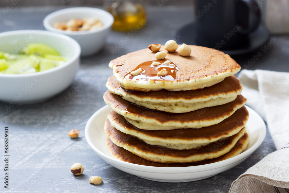 Vegetarian breakfast of pancakes, coffee, honey, nuts and fruits. Vegetarian breakfast of pancakes, coffee, honey, nuts and fruits.