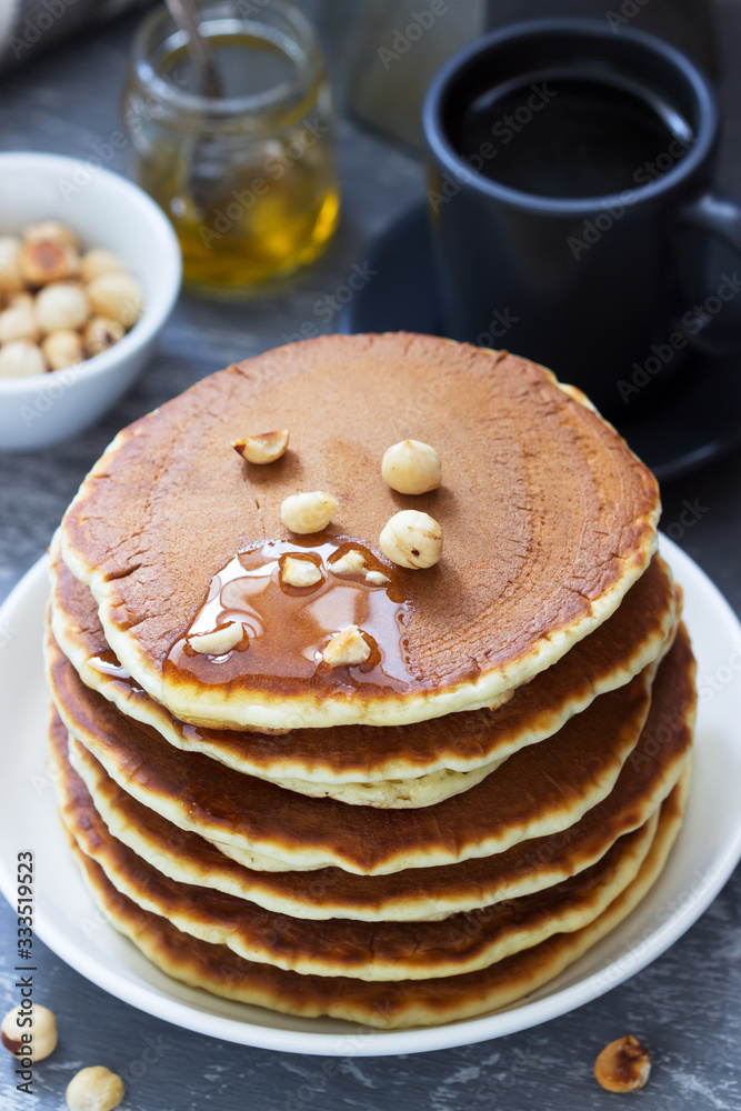 Vegetarian breakfast of pancakes, coffee, honey, nuts and fruits. Vegetarian breakfast of pancakes, coffee, honey, nuts and fruits.