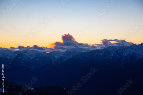 Beautiful Dramatic Canadian Mountain Landscape View during a sunny and cloudy winter sunset. Taken in Squamish, British Columbia, Canada. Nature Background