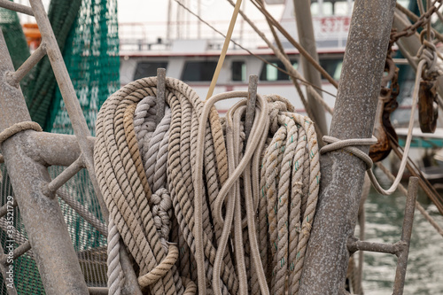 Various nautical ropes ready for use on deck of a commercial fishing boat in amarina in Rockport, Texas, in close up with limited focus and shallow depth of field.