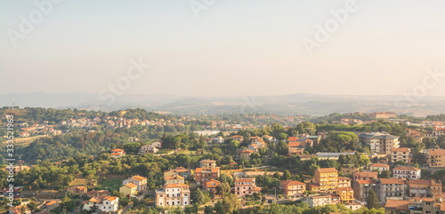 Small town with tiled roofs on hillside in Italy
