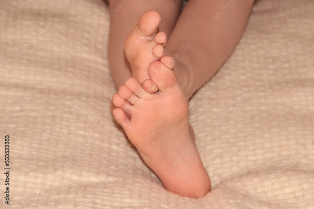 Children's feet on a blanket. Feet on the bed. Children's feet on a blanket. Feet on the bed.