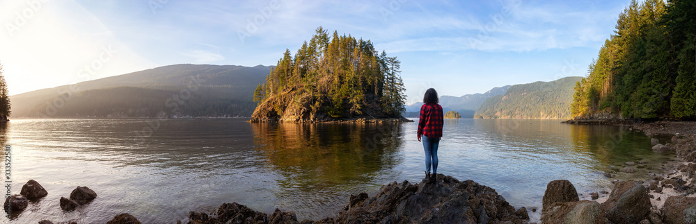 Girl Hiking in the Canadian Landscape during a vibrant winter sunset. Hike on Jug Island Trail in Belcarra, Vancouver, British Columbia, Canada. Nature Panorama Background Girl Hiking in the Canadian Landscape during a vibrant winter sunset. Hike on Jug Island Trail in Belcarra, Vancouver, British Columbia, Canada. Nature Panorama Background
