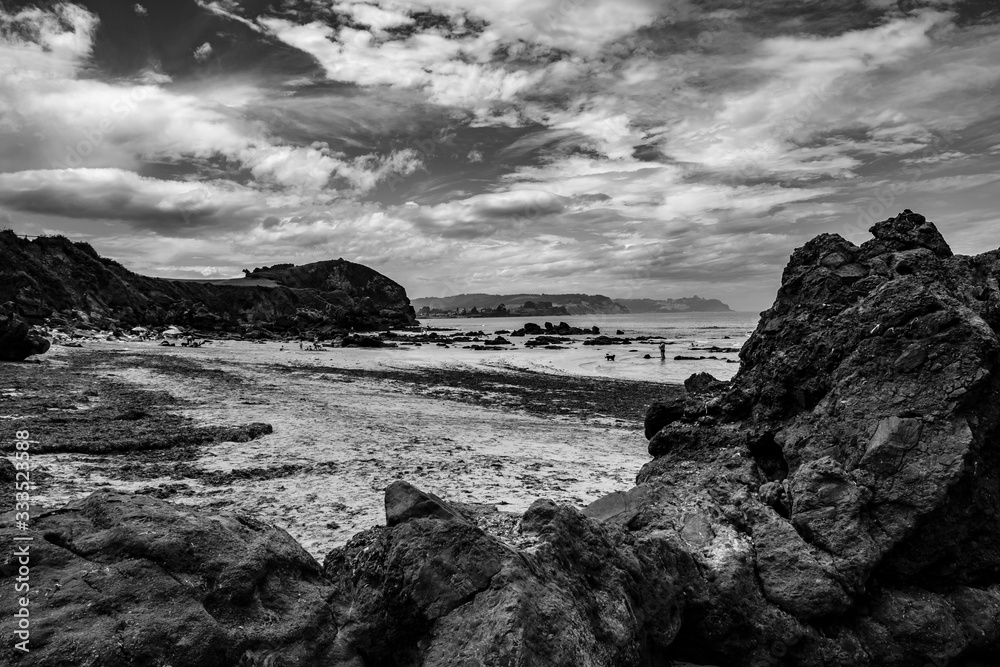 playa en asturias con rocas blanco y negro
