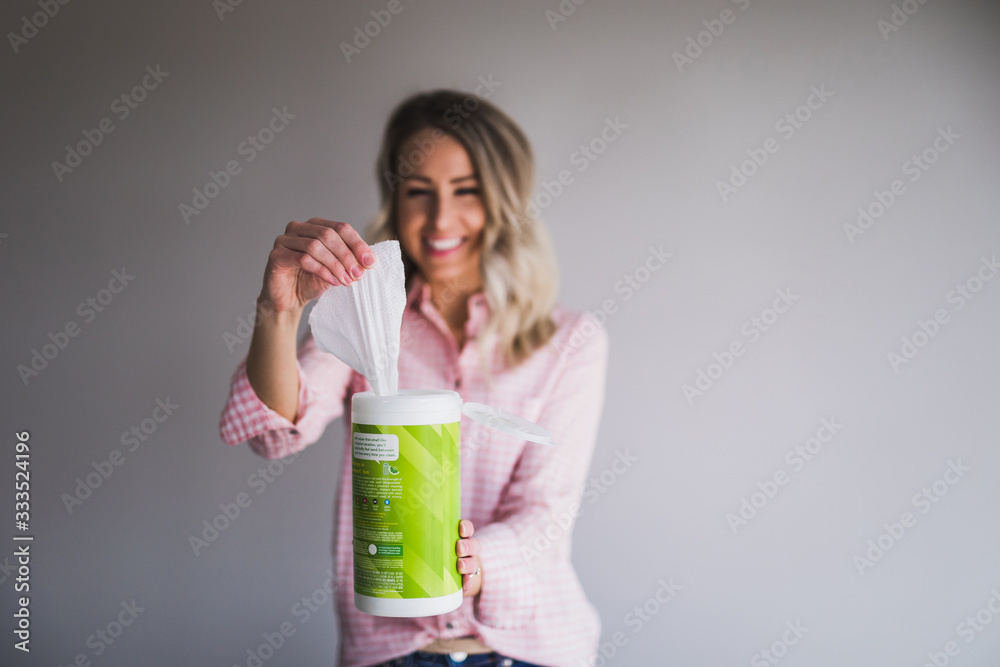 Young woman pulling a disinfectant wipe out from the container Young woman pulling a disinfectant wipe out from the container