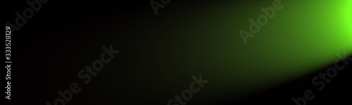 Green light shining from the side on a black background with a lot of space