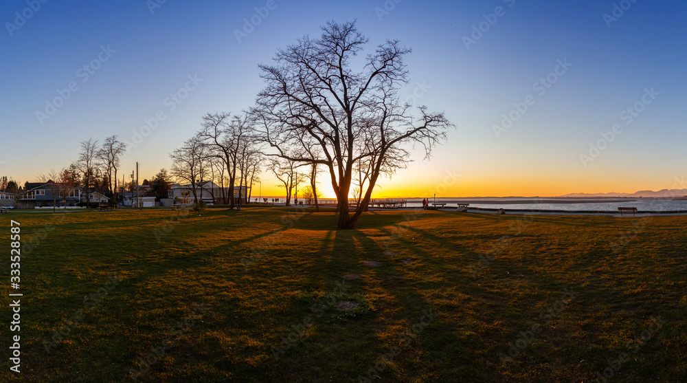 Beautiful Panoramic View of a park by the Pacific Ocean Shore, Blackie Spit, during a vibrant sunny winter sunset. Located in White Rock, Vancouver, British Columbia, Canada. Panorama