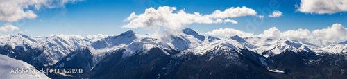 Whistler  British Columbia  Canada. Beautiful Panoramic View of the Canadian Snow Covered Mountain Landscape during a cloudy and vibrant winter day. Nature Background Panorama
