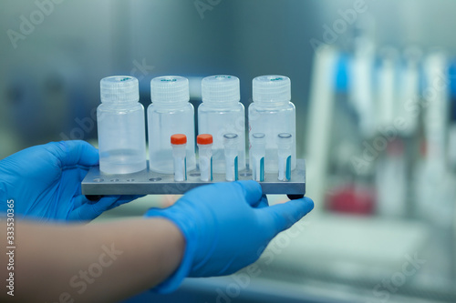 Test kit to detect novel coronavirus in patient samples. RT-PCR kit converts viral Covid19 RNA to DNA and amplify specific region of 2019-nCov gene coding spike protein. Hands in gloves hold reagents. photo