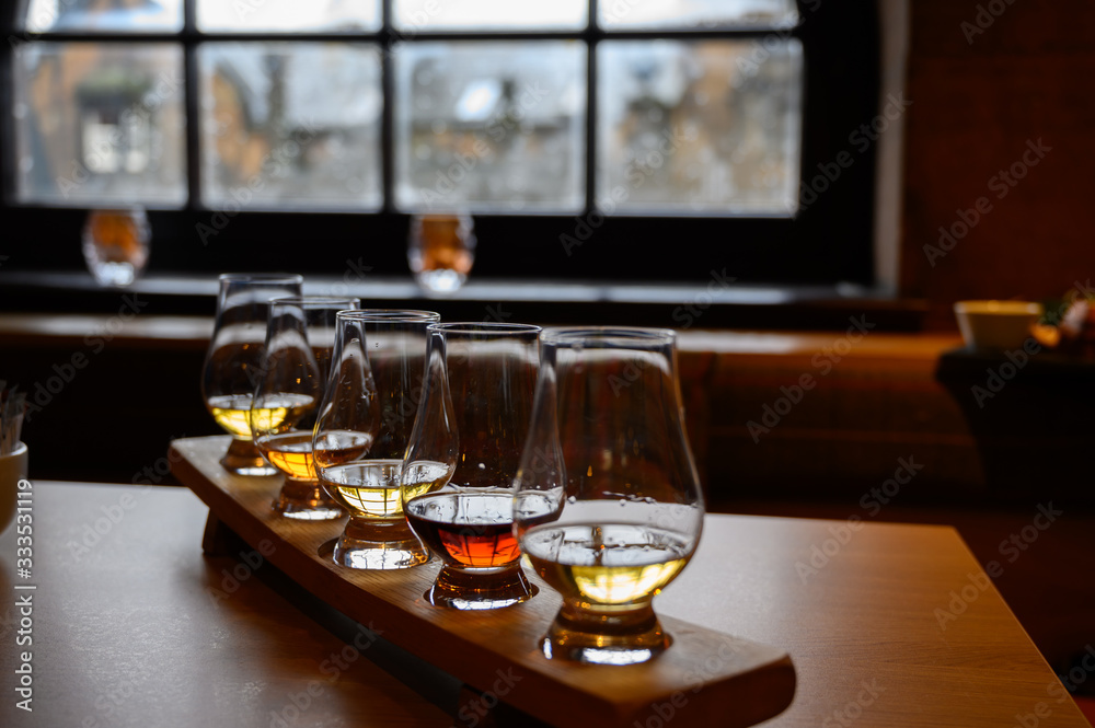 Flight of Scottish whisky, tasting glasses with variety of single malts or blended whiskey spirits on distillery tour in Scotland - obrazy, fototapety, plakaty 