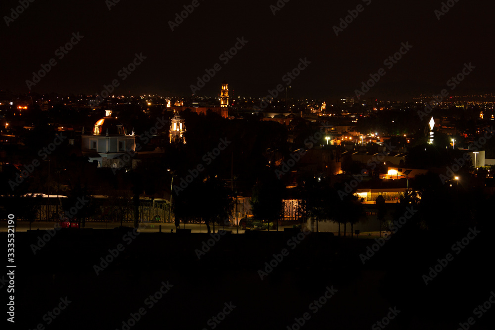 Fototapeta premium Churches that mix between the houses and buildings in the city of Puebla Mexico illuminated at night
