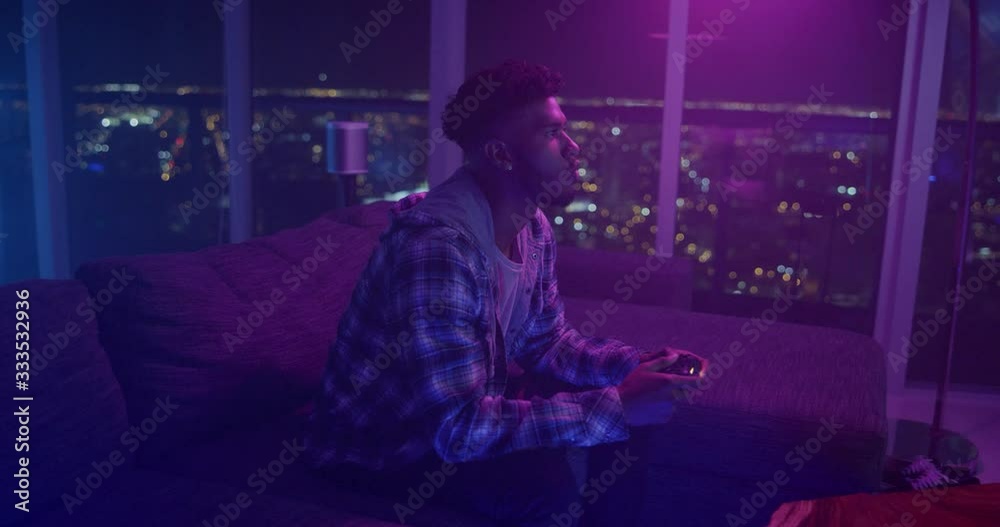 Man playing video games at night in apartment Man playing video games at night in apartment