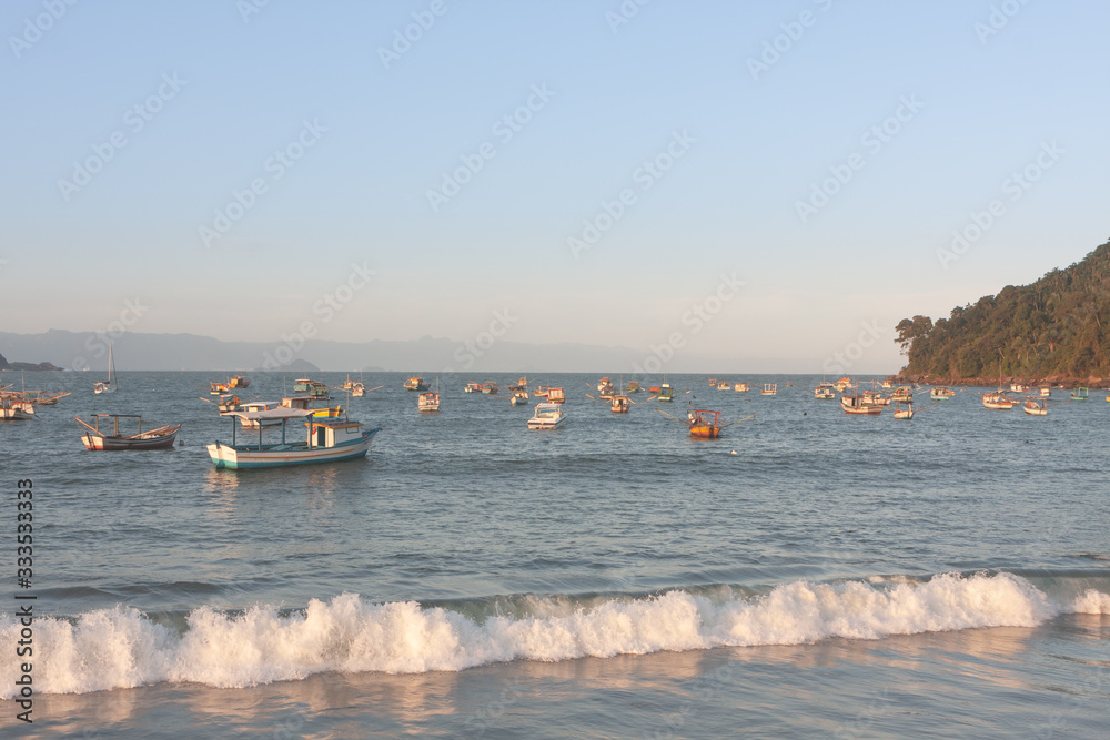 Sunset at Perequê beach with anchored fishermen's boats, Guaruja, Brazil