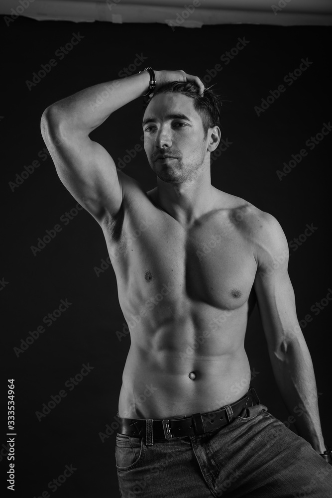 black and white studio shoot of strong athletic man on dark background black and white studio shoot of strong athletic man on dark background