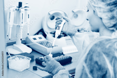 a female scientist makes PCR DNA tests in a modern chemical and bacteriological laboratory.