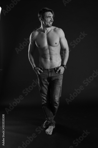 black and white studio shoot of strong athletic man on dark background