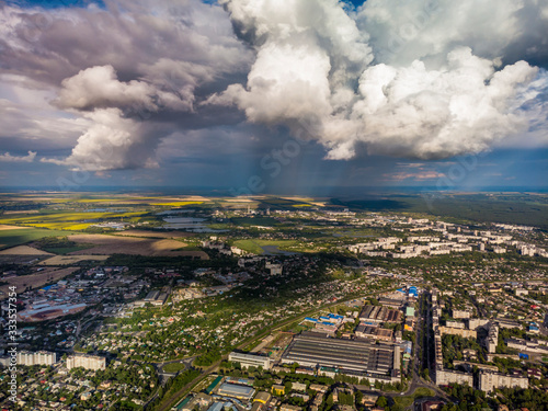 Top view of the city and yellow, green fields. Beautiful clouds.