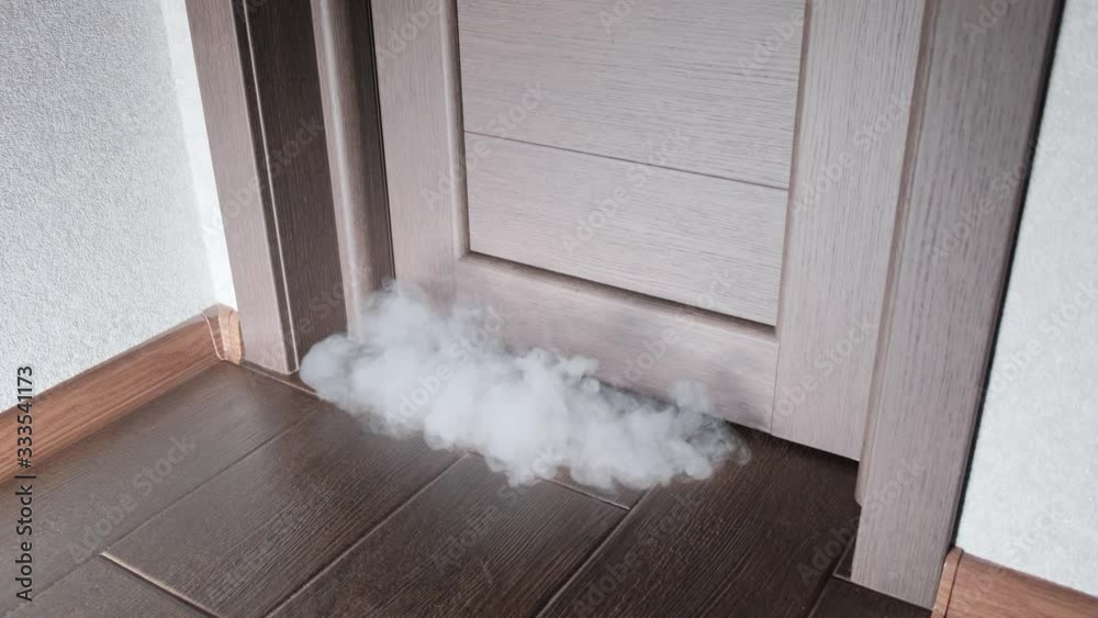 Fire in a residential area. Smoke from under the door below. Fire in an  apartment with a smoky room