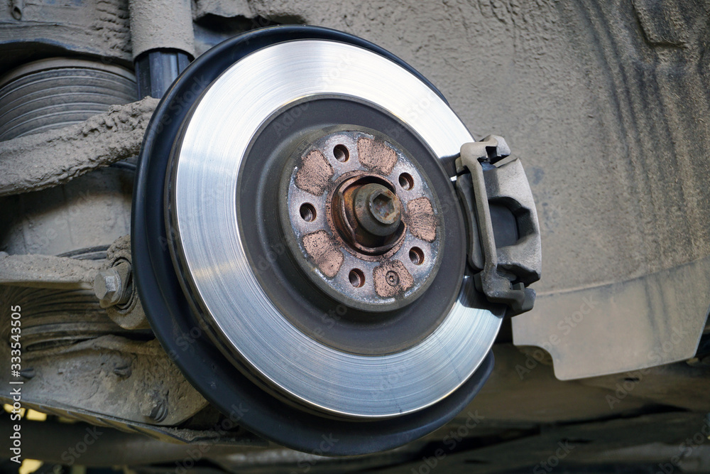 Brake disc, brake caliper mounted on a modern car. Concept of service and car repair. Brake disc, brake caliper mounted on a modern car. Concept of service and car repair.