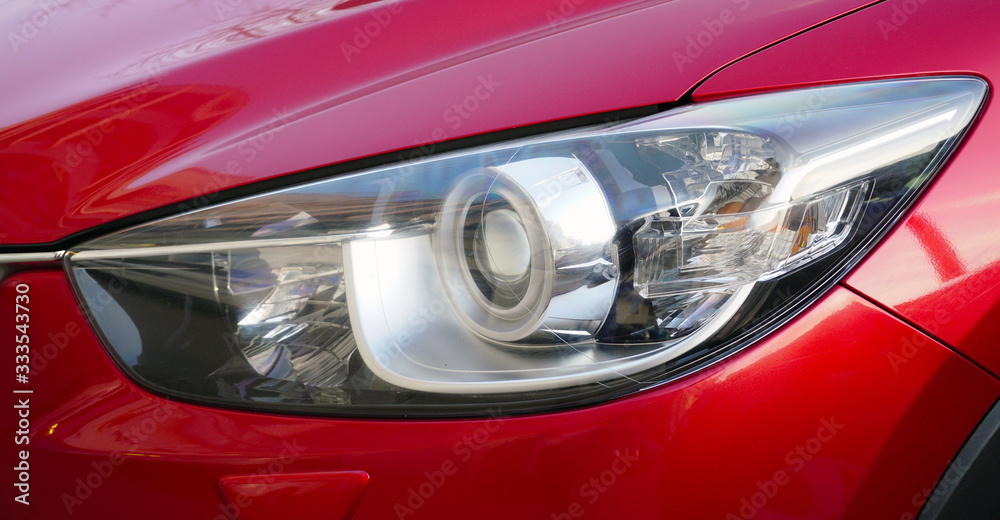 Front view of a modern luxury car. Futuristic design of headlights and front of the car. Car service and repair concept.