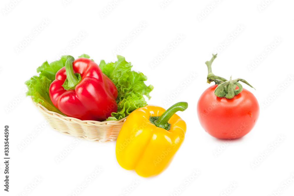 Ripe fresh organic vegetables in a basket and tomato in dew drops isolated on a white background