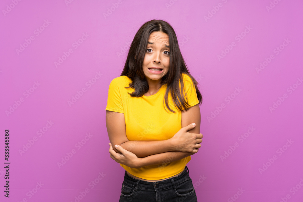 Young brunette girl over isolated background freezing