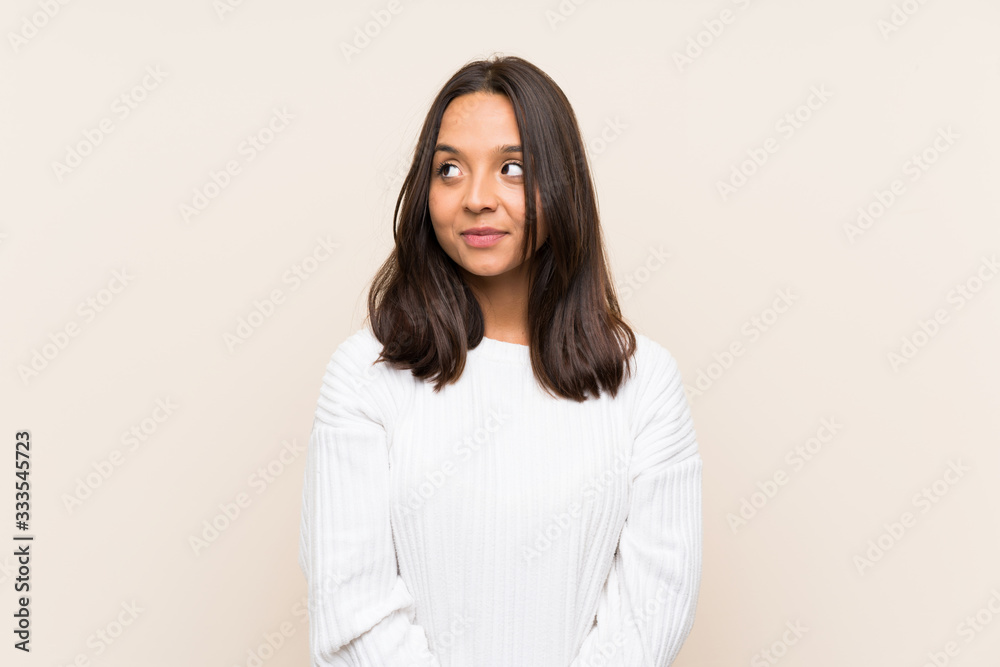 Young brunette woman with white sweater over isolated background standing and looking to the side Young brunette woman with white sweater over isolated background standing and looking to the side