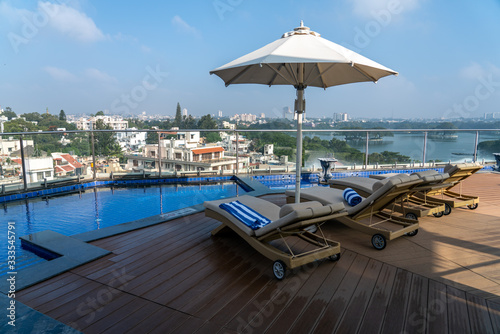 View of Recliner Seats By Roof Top Pool With Bangalore Skyline in the Background