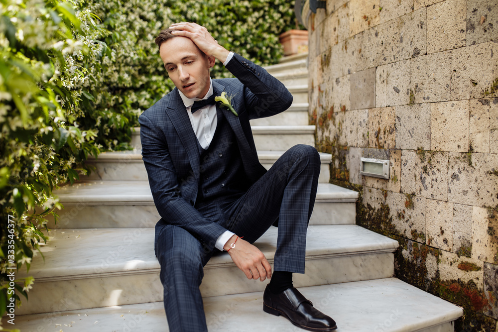 Young man in blue suit in the garden Young man in blue suit in the garden