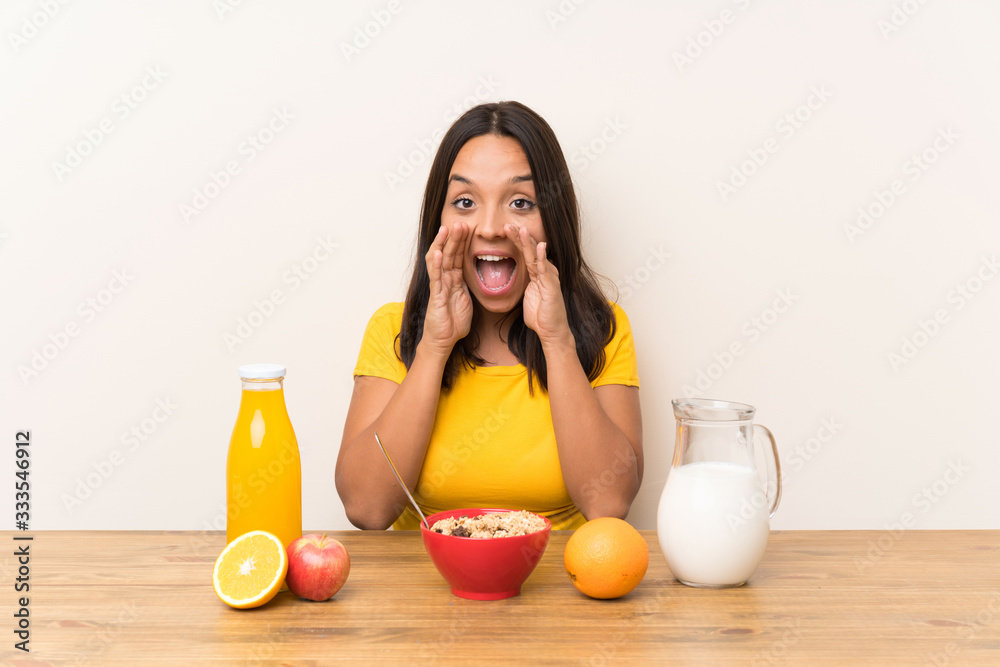 Young brunette girl having breakfast milk shouting with mouth wide open Young brunette girl having breakfast milk shouting with mouth wide open